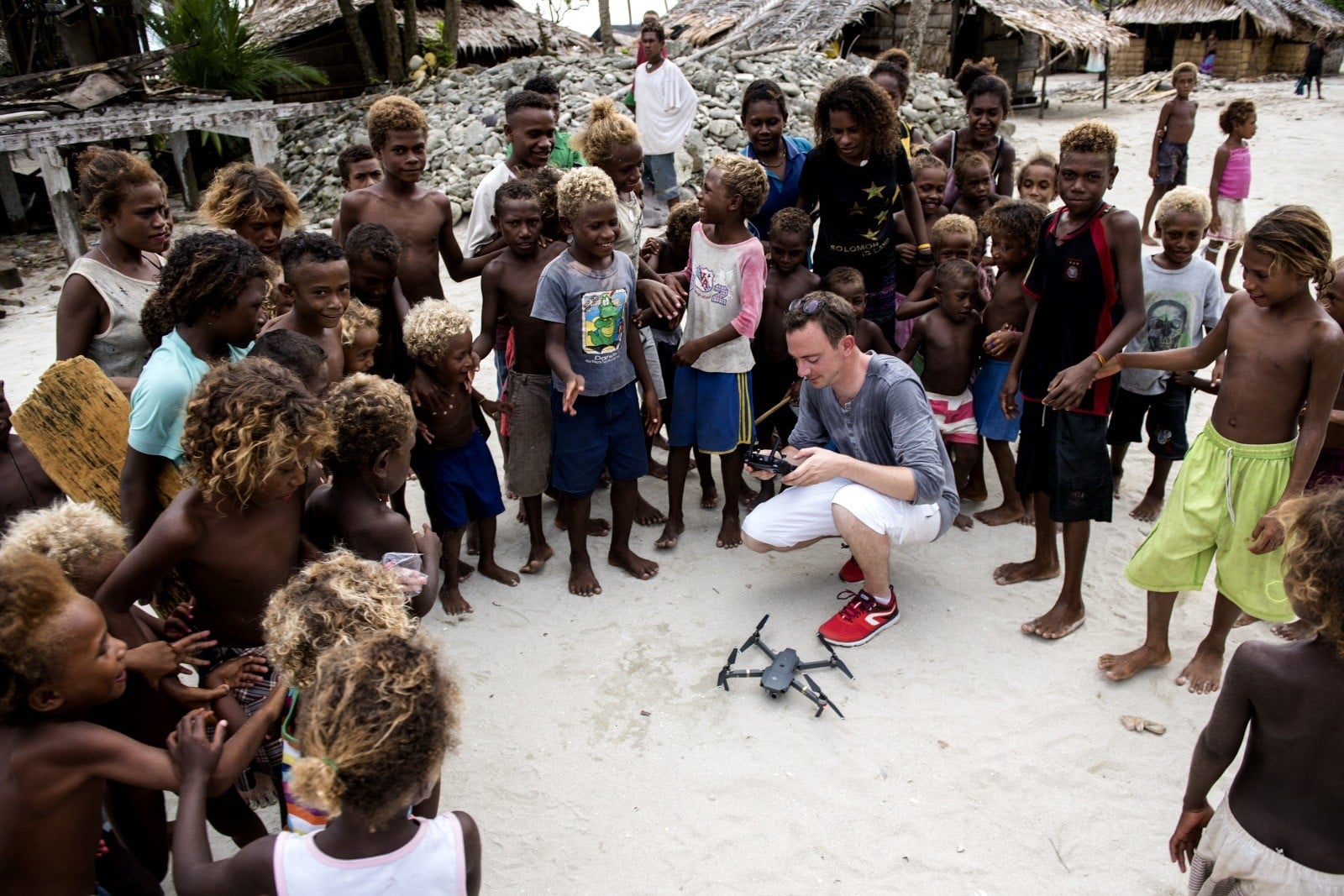 elier vannier drone Groupe d'enfants entourant un videaste accroupi devant un drone