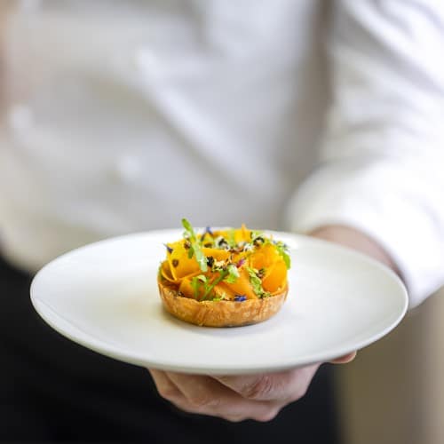 Assiette gastronomique dressée avec une petite tartelette au saumon
