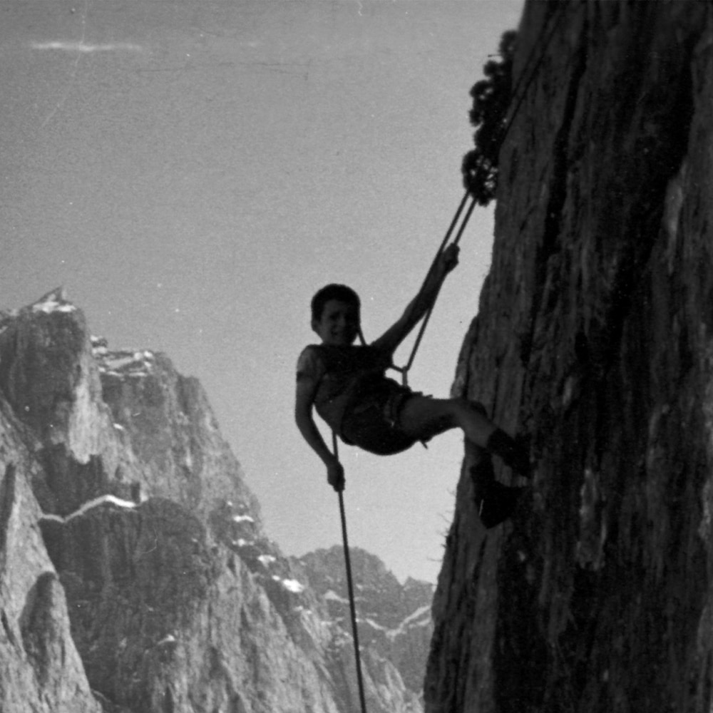Reinhold Messner, a hanging child, who abseils down a rock in the high mountains. 